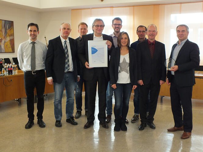 Bildunterschrift: Persönliche Übergabe des Axians Infoma Innovationspreises 2018 beim Finalist Verbandsgemeindeverwaltung Höhr-Grenzhausen v.l.n.r.: Marco Weißer, Joachim Breiden und Philipp Menges (VG Höhr-Grenzhausen), Stefan Keltsch (Axians Infoma), Sebastian Kilb (VG Höhr-Grenzhausen), Martina Saal (Diakonie Westerwaldkreis), Klaus Specht (VG Höhr-Grenzhausen), Verbandsbürgermeister Thilo Becker (VG Höhr-Grenzhausen), Holger Schmelzeisen (Axians Infoma); Quelle: Verbandsgemeindeverwaltung Höhr-Grenzhausen