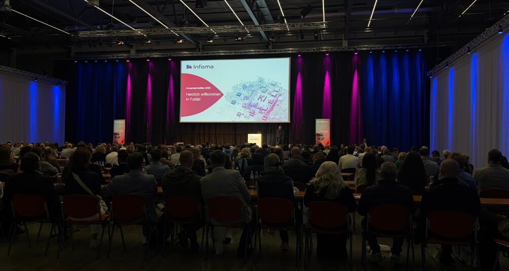 Vortragshalle des Infoma Anwendertreffens Finanzwesen mit großer Präsentationsleinwand und zahlreichen Teilnehmenden im Publikum. Die Veranstaltung bietet Raum für Fachvorträge, Wissenstransfer und den Austausch zu aktuellen Themen der digitalen Verwaltung und des kommunalen Finanzwesens.